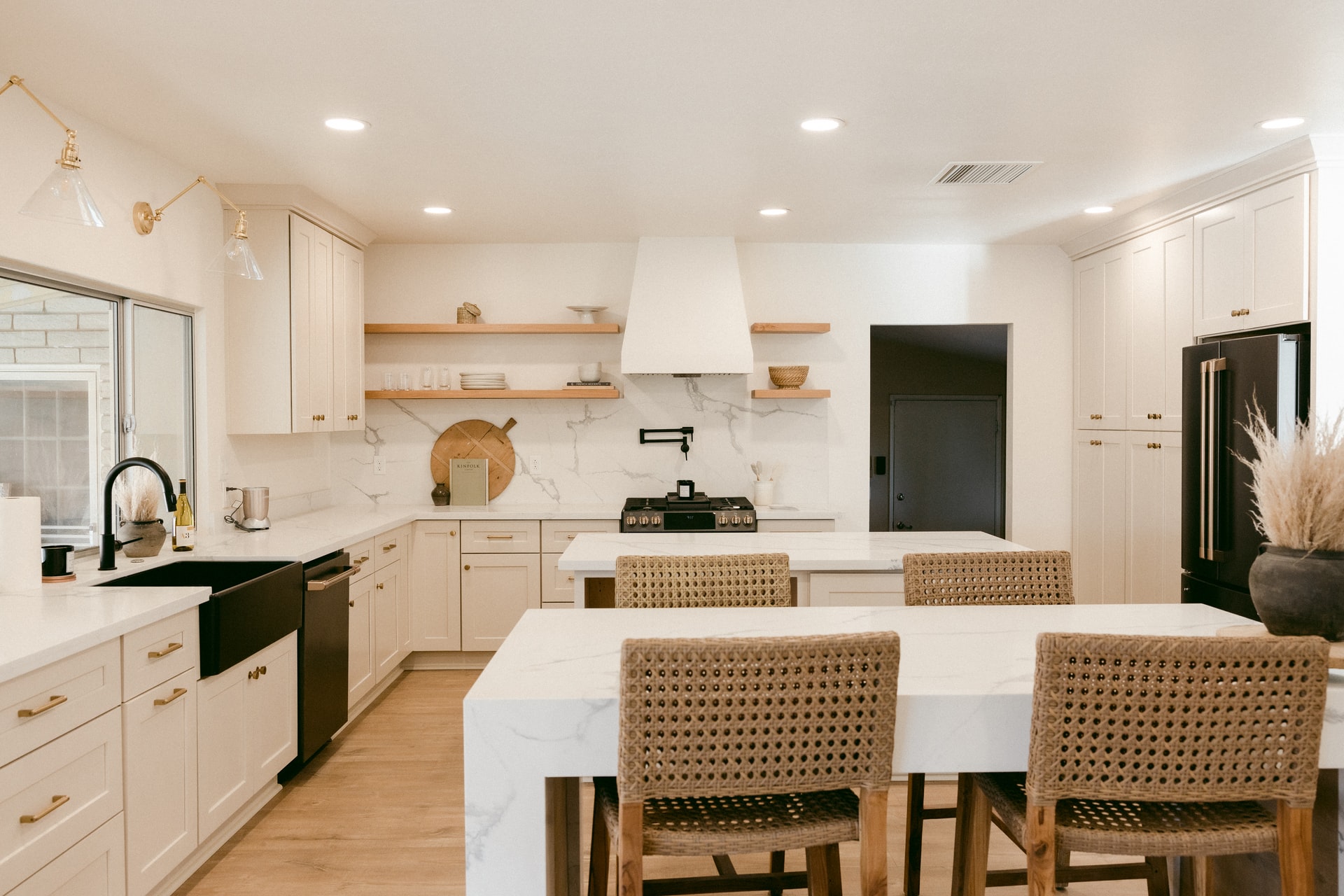 Photo of boho style kitchen with light wood cabinets and marble counters.