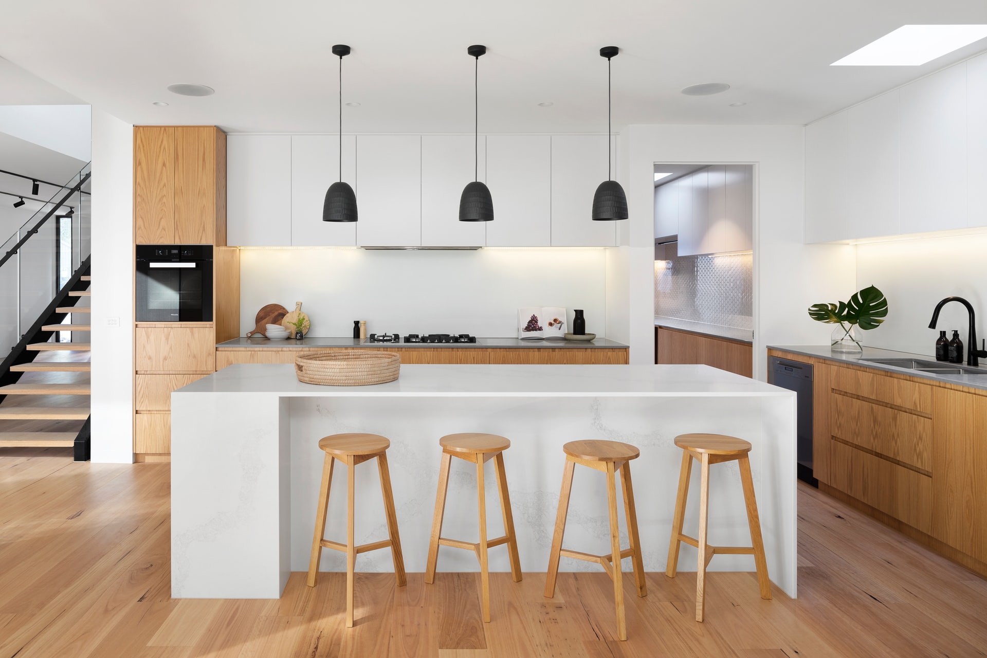 Photo of bright kitchen with white cabinets and marble counters.